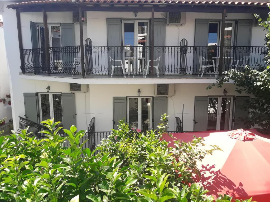 un edificio de apartamentos con sillas en el balcón en Pension Nikolas, en Skiathos