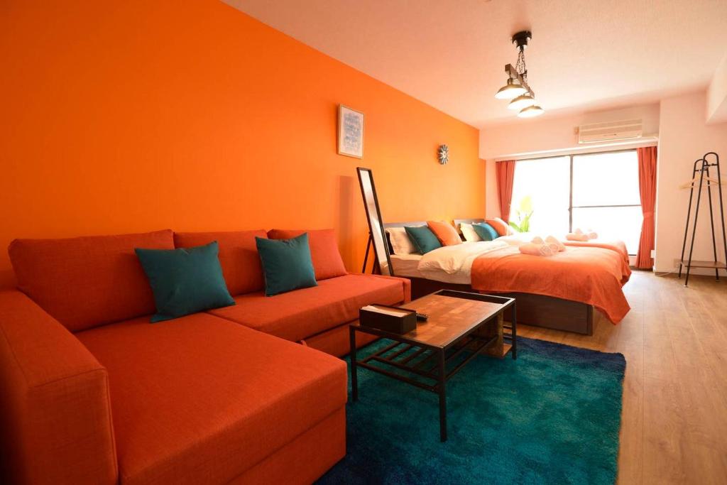 an orange living room with a couch and a bed at Roppongi Azabu Sunshine Resort House in Tokyo