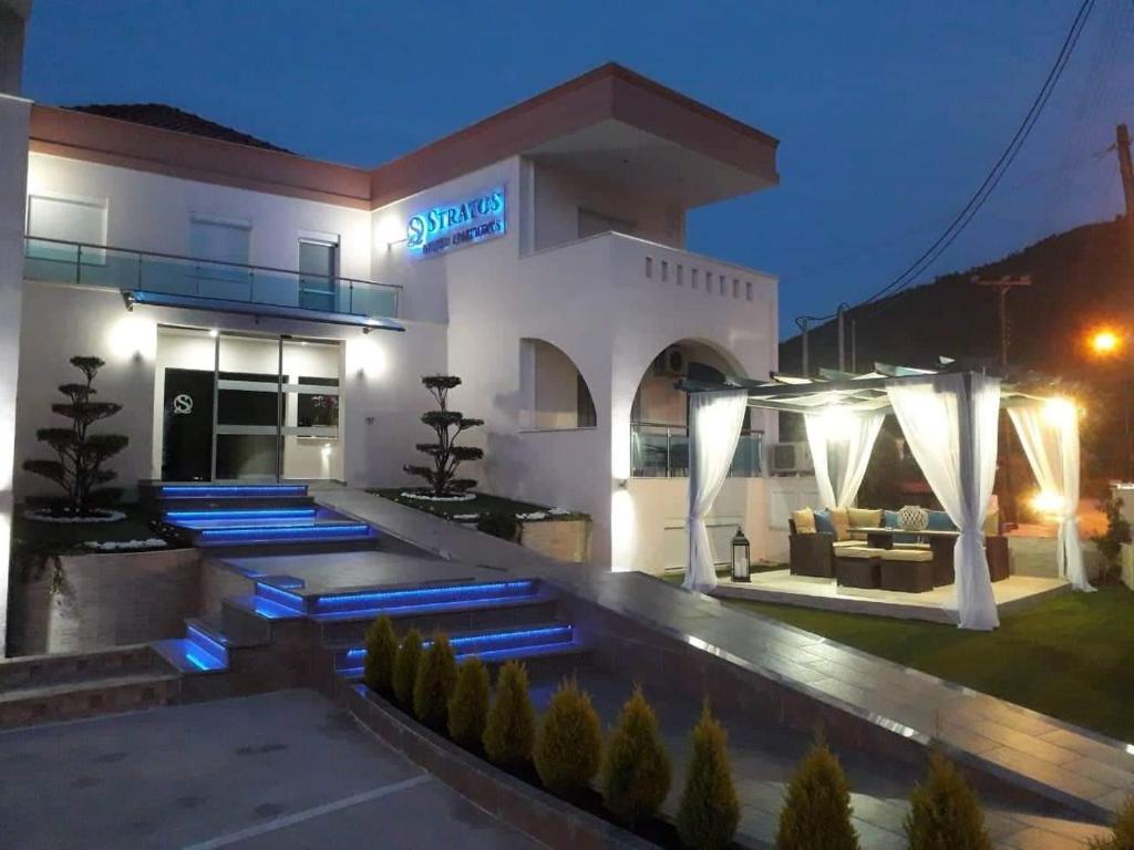 a large white building with a sign on it at night at Stratos Deluxe Apartments in Skala Potamias