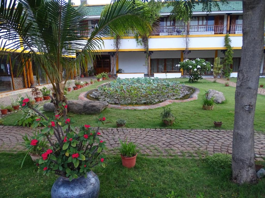 a garden in front of a building with flowers and plants at Nalla Eco Beach Resort in Puducherry