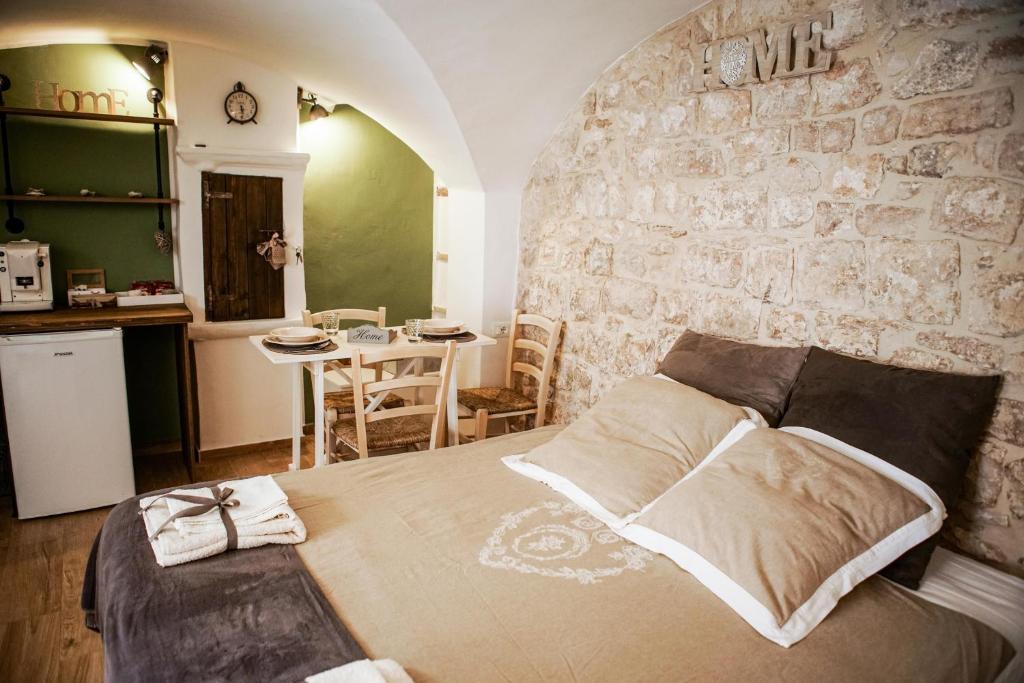 a bedroom with a large bed and a stone wall at HOME 5 - Via Nuova in Putignano