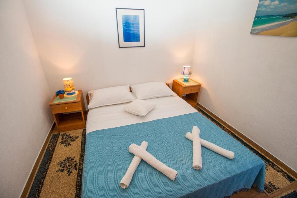een kamer met een bed met drie kruisen erop bij Apartments PIVAC - Lokva Rogoznica in Lokva Rogoznica