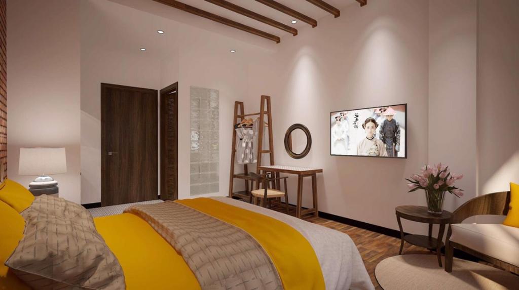 um quarto com uma cama grande e um cobertor amarelo em Banana Flower Homestay em Da Nang
