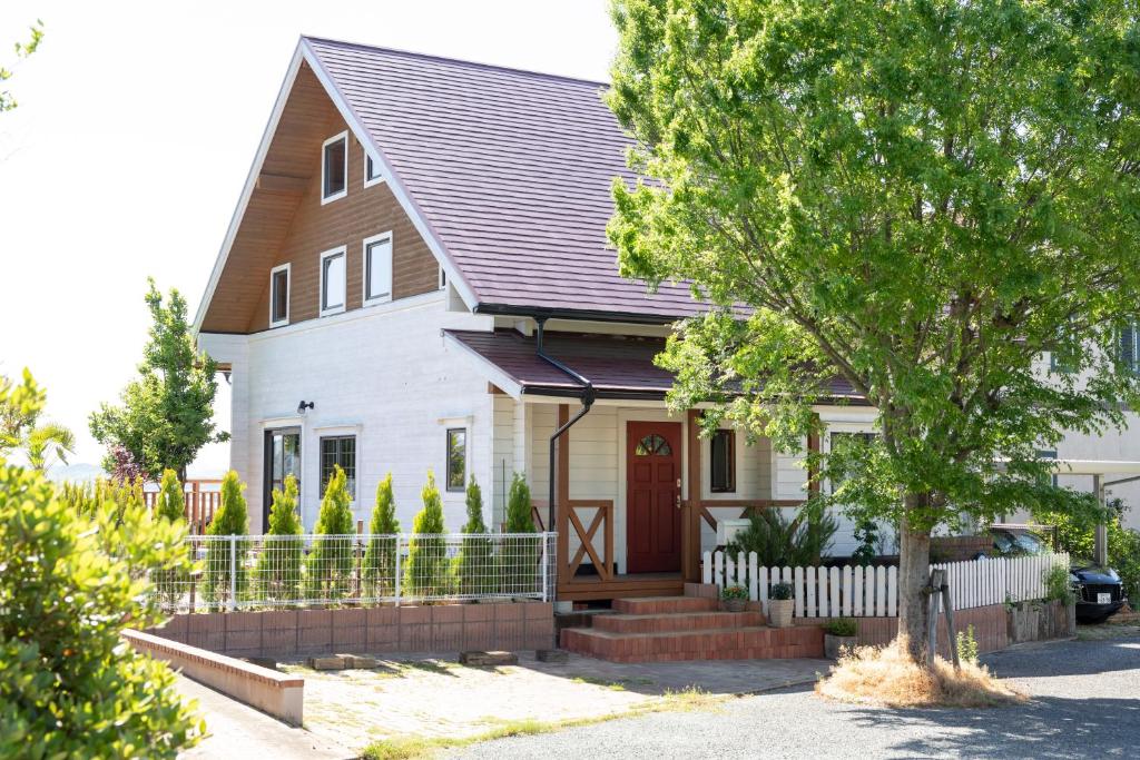 a white house with a brown roof at Keiko's Home Beautiful Resort Villa 20 min to Tenjin free park in Itoshima