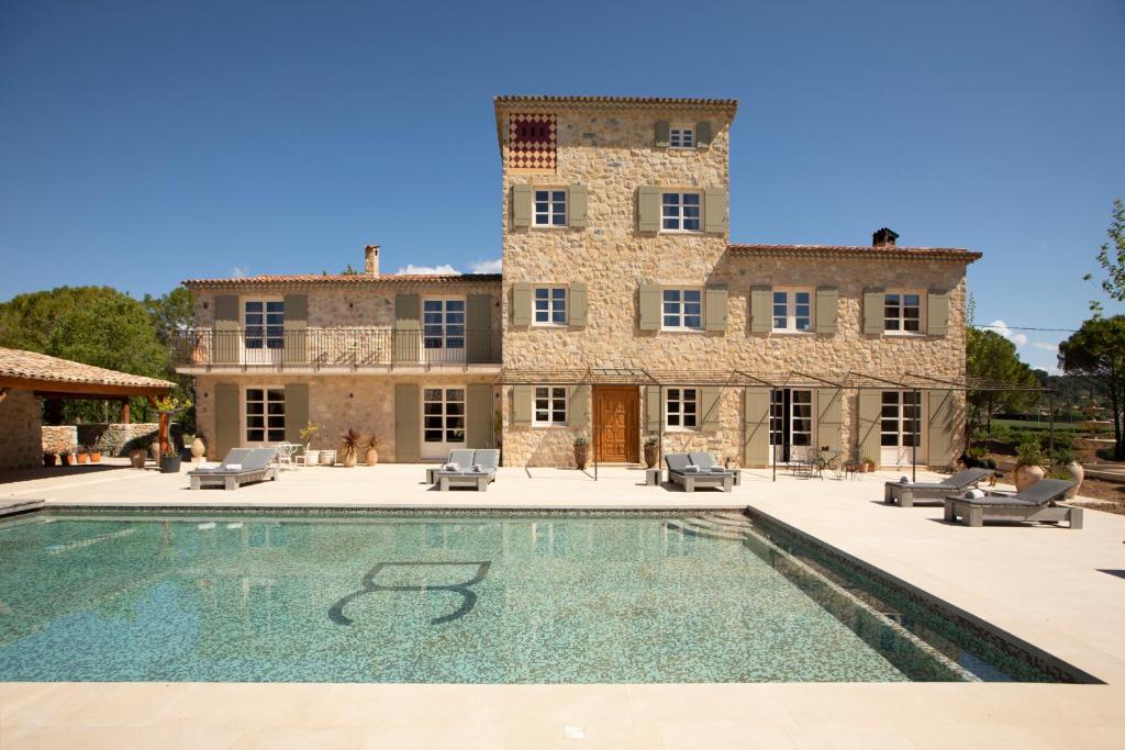 a house with a swimming pool in front of a building at Domaine De La Chapelle in Lorgues