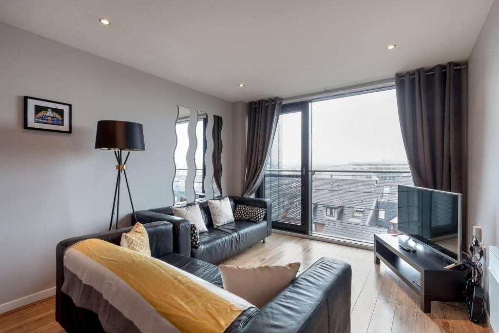 sala de estar con sofá y TV en Modern Riverfront Apt. 10 mins from Hydro/SECC en Glasgow