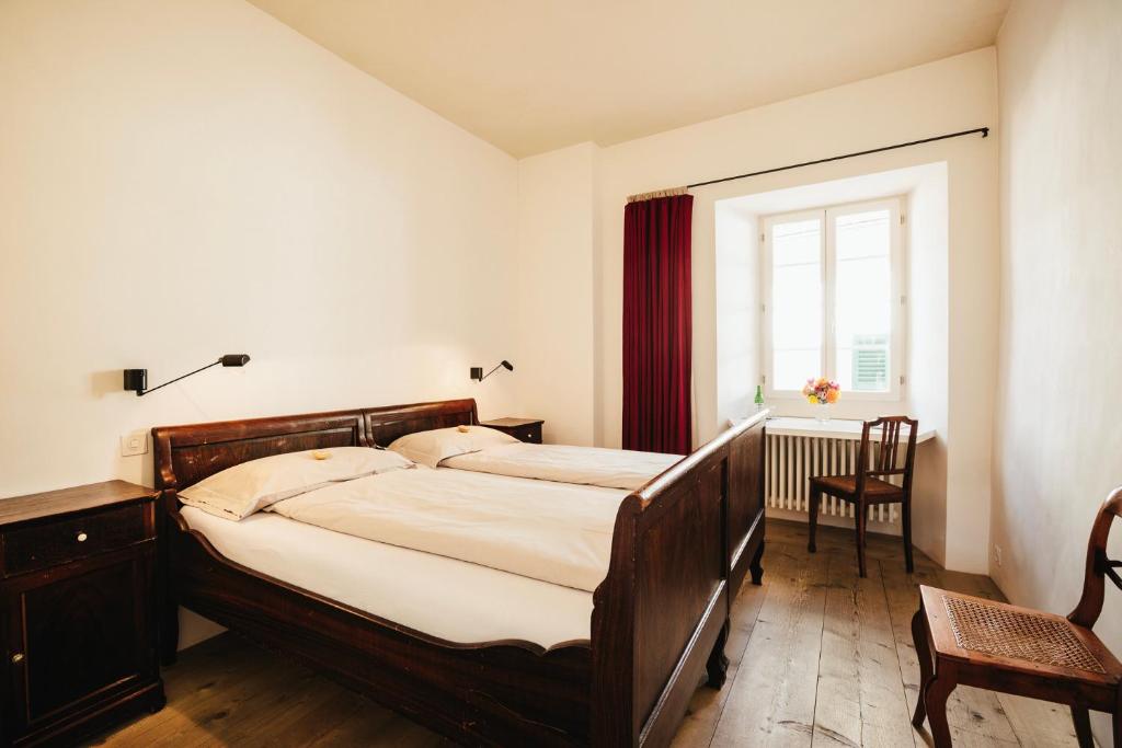 um quarto com uma cama grande e uma janela em Historic Hotel Albrici em Poschiavo