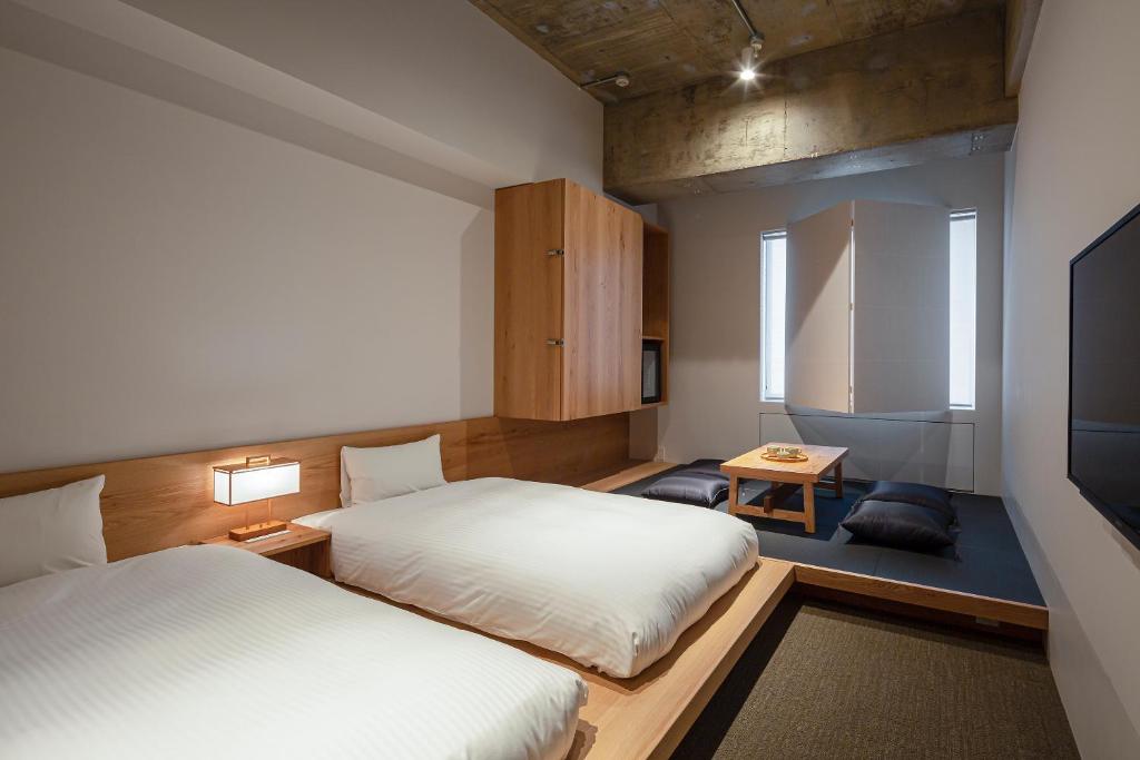 Postel nebo postele na pokoji v ubytování TSUGU Kyoto Sanjo by THE SHARE HOTELS