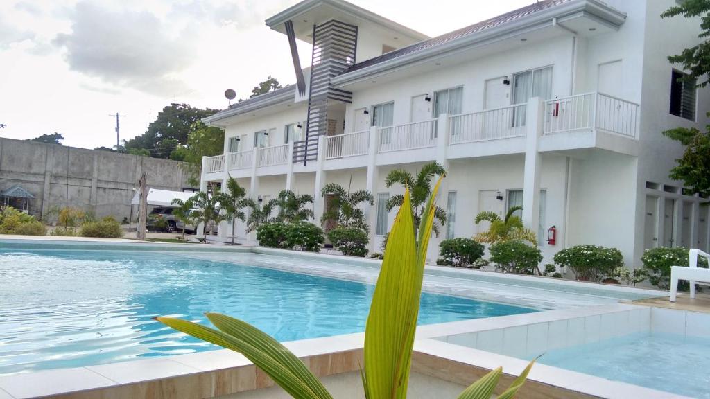 a hotel with a swimming pool in front of a building at Seascape Beach Resort Oslob in Oslob