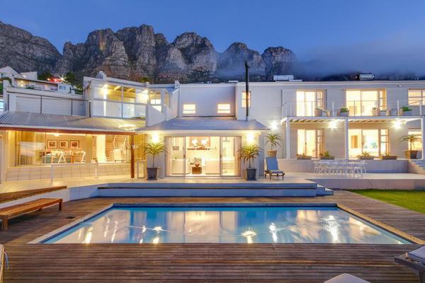 a large house with a swimming pool in front of it at Amber Place in Cape Town