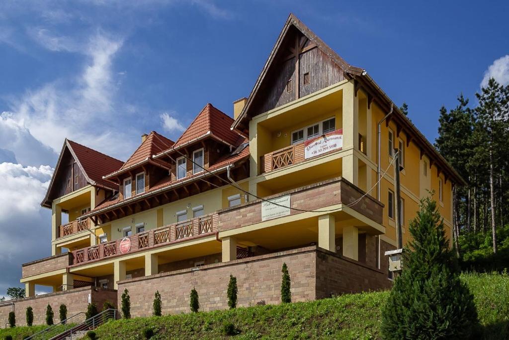 a large yellow building on top of a hill at M&F Apartman in Egerszalók