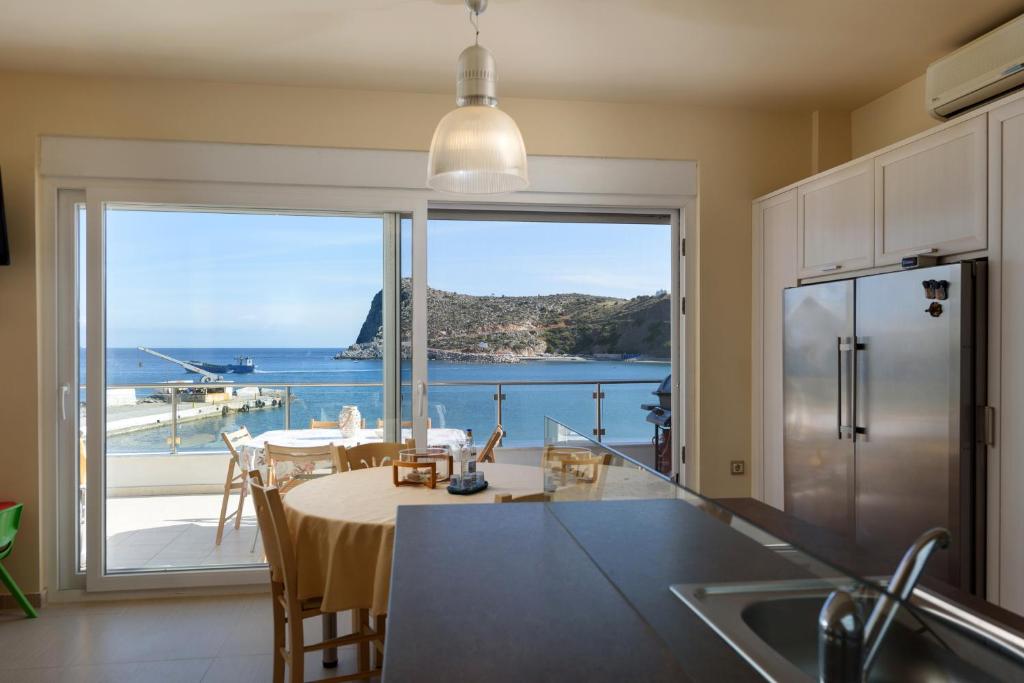 a kitchen with a table and a view of the ocean at Beach Front Condo South Crete in Kaloi Limenes