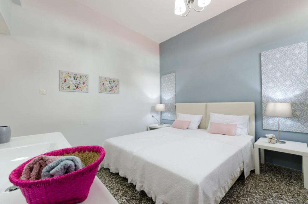 a white bedroom with a bed and a bath tub at Stylish Studios in Moírai