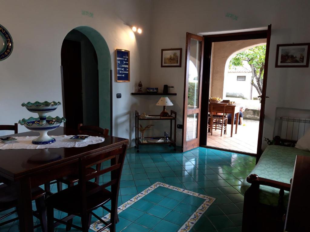 uma sala de estar com uma mesa e cadeiras e uma porta aberta em Villetta panoramica em Maratea