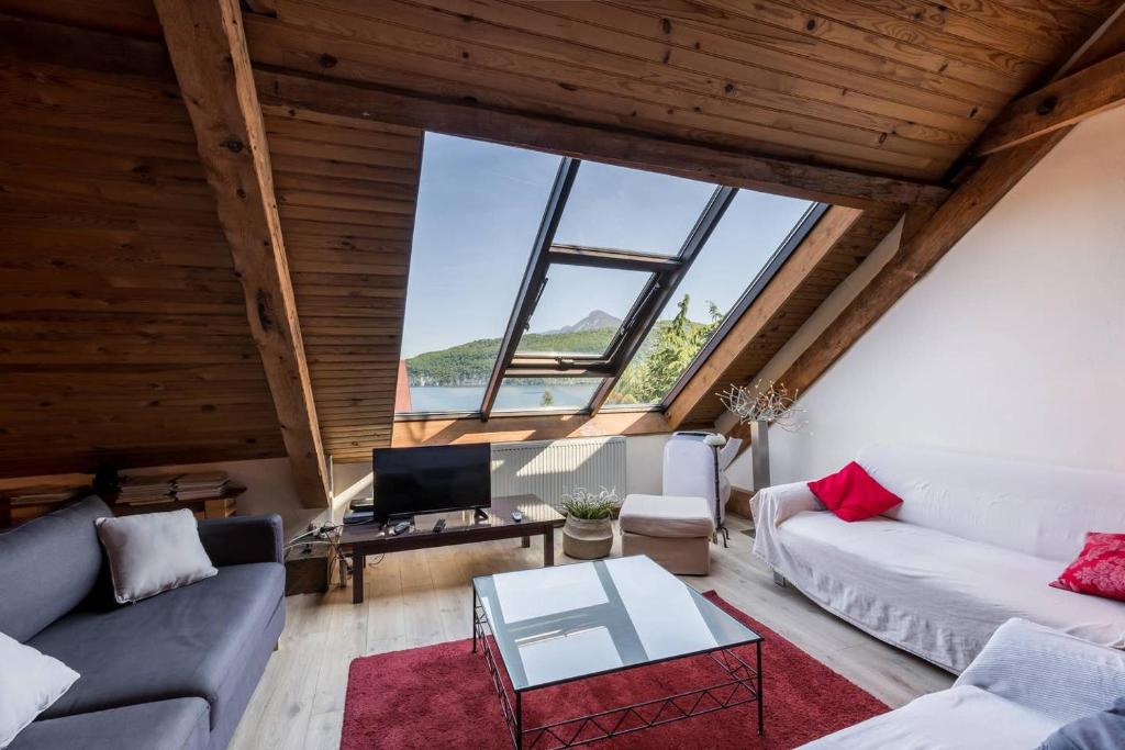 a living room with a couch and a table at Duplex au Bord du Lac in Duingt