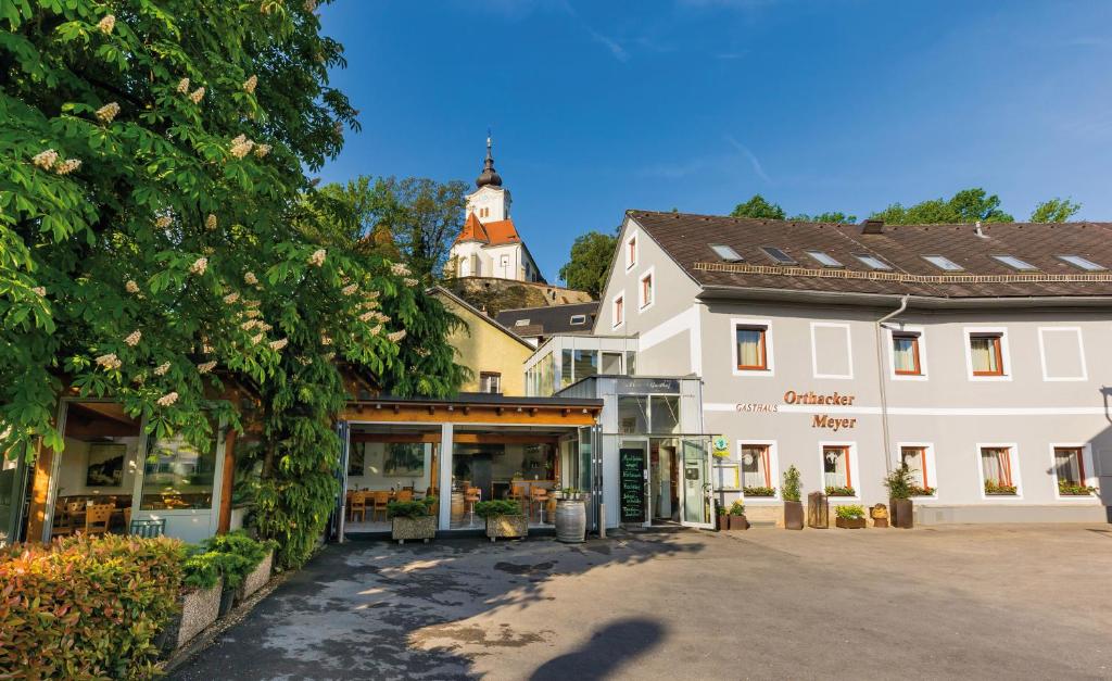 un grand bâtiment blanc avec une tour d'horloge dans une ville dans l'établissement Frühstückspension Meyer, Familie Orthacker, à Graz