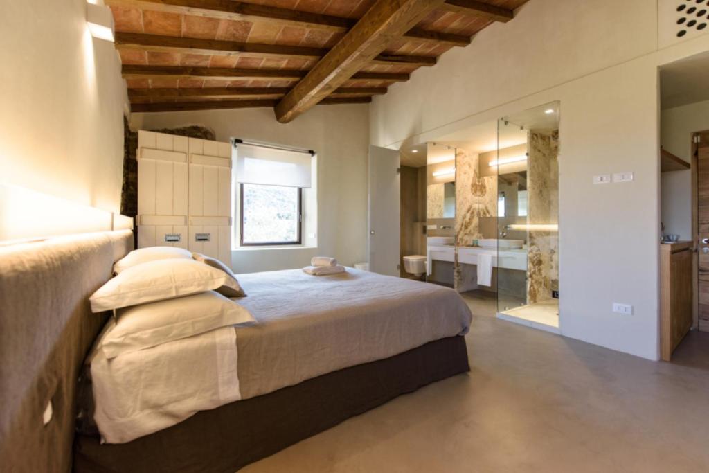 a bedroom with a large bed and a bathroom at Torre di Baratti Bio Resort in Populonia