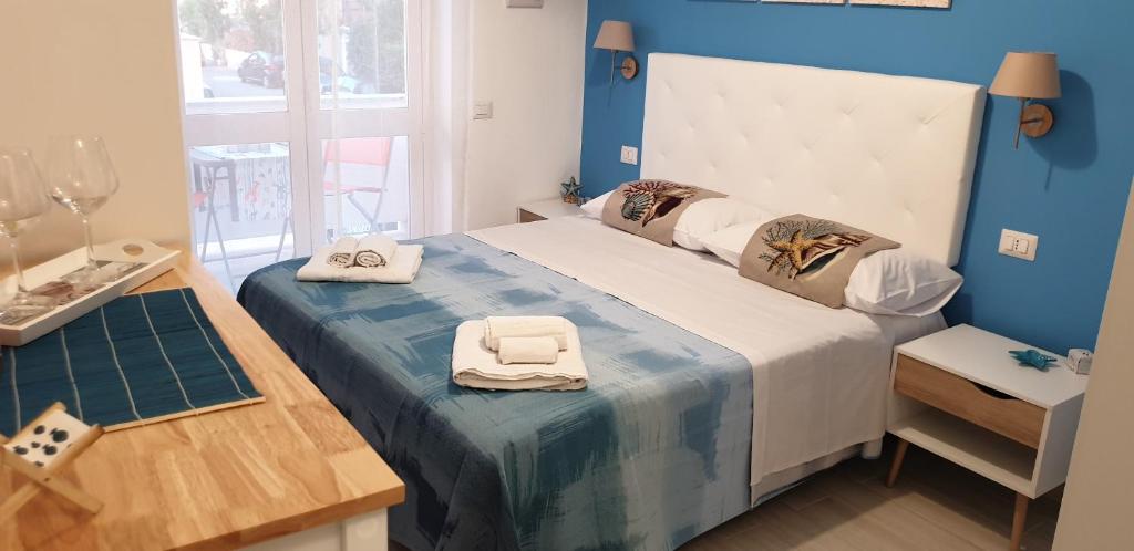 1 dormitorio con 1 cama grande y pared azul en ele&gio accomodation en Tropea