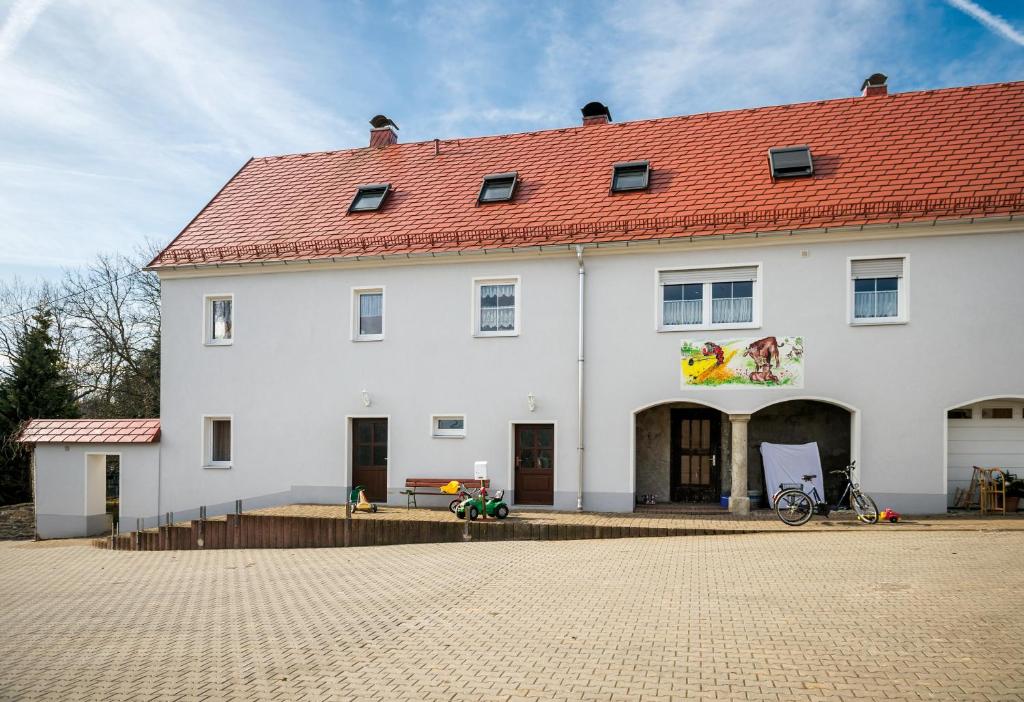 a large white building with a red roof at Ferienwohnung am Bauernhof in Oederan