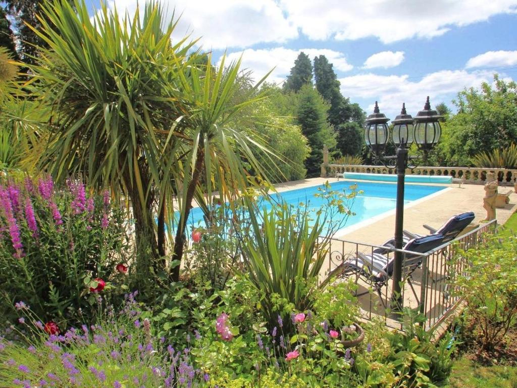a garden with a swimming pool and some plants at Daisy Lodge in Looe