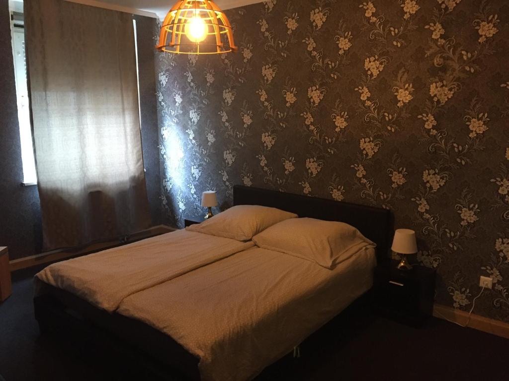1 dormitorio con cama y lámpara de araña en Viktor, en Pirmasens