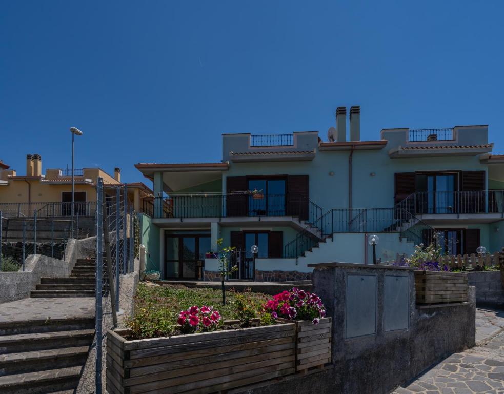 una casa con escaleras y flores delante en Appartamento Belvedere Sassos, en Tresnuraghes