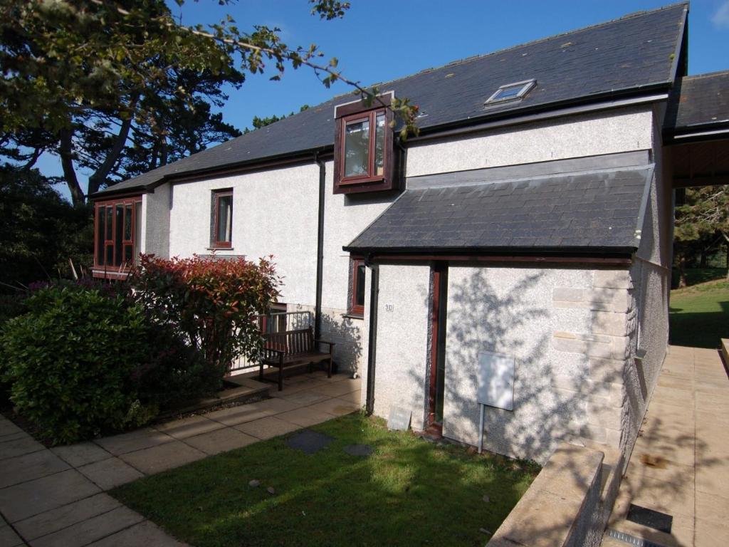a white building with a window on the side of it at Pine Cottage in Falmouth