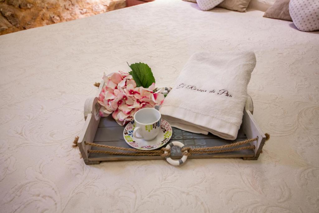 - un plateau avec une tasse et des fleurs sur le lit dans l'établissement Valterra y Tosal, à Torres-Torres