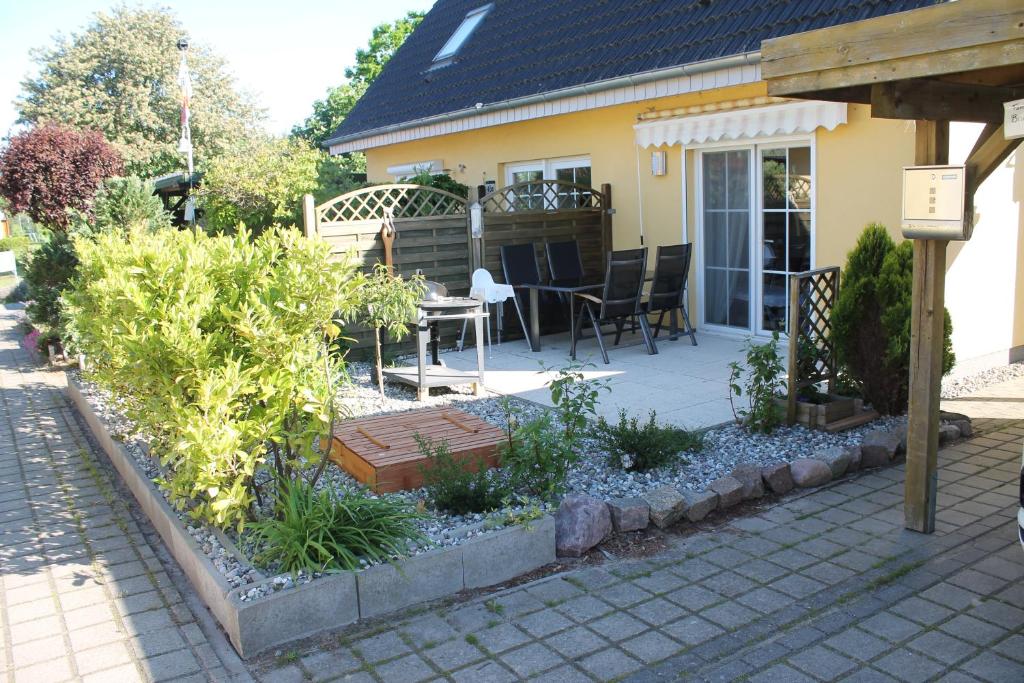 un patio con una mesa y algunas plantas frente a una casa en Ferienwohnung Charlotte en Ostseebad Karlshagen