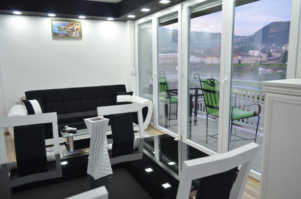 a living room with a couch and a balcony at Apartments Sokolović in Višegrad
