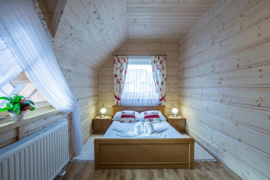 ザコパネにあるWilla nowotarska centrumの木製の部屋にベッド1台が備わるベッドルーム1室があります。