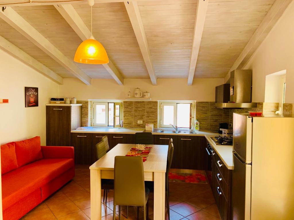 uma cozinha com um sofá, uma mesa e um frigorífico em Orchidea Gialla em Gaeta