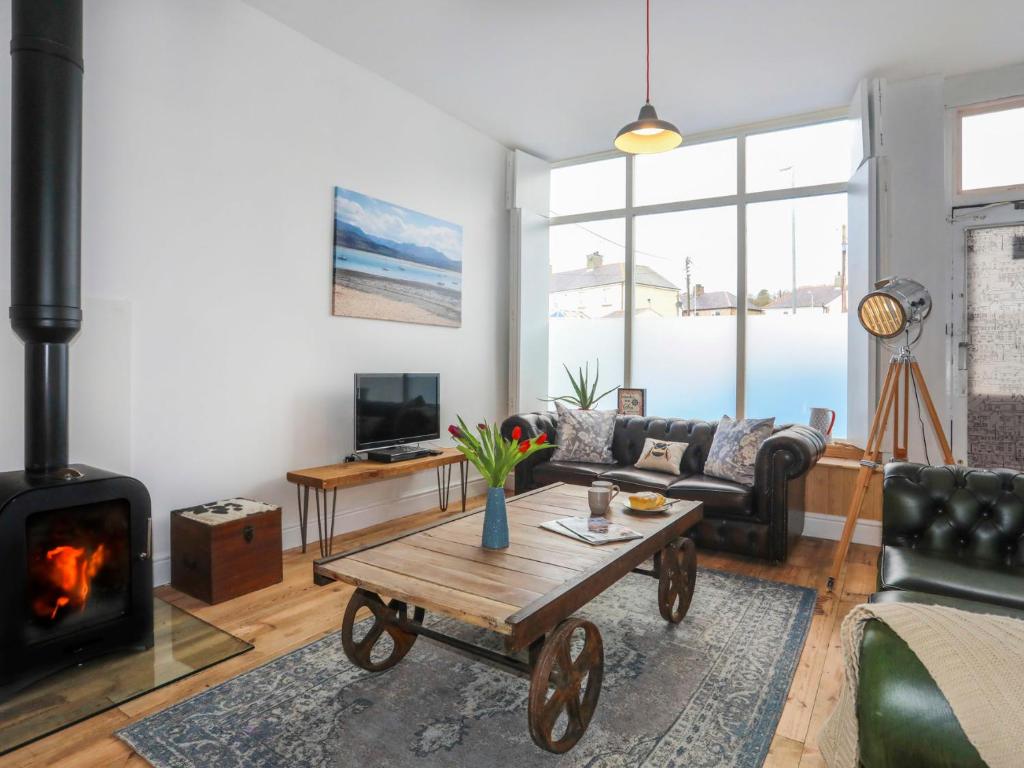 a living room with a couch and a fireplace at Gwalia Stores in Beaumaris