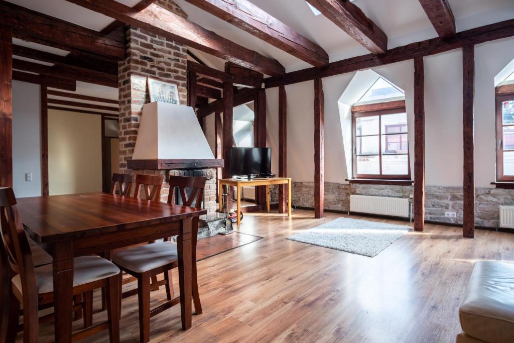 a living room with a wooden table and a brick wall at Dream Stay - Five Bedroom Penthouse in Old Town in Tallinn