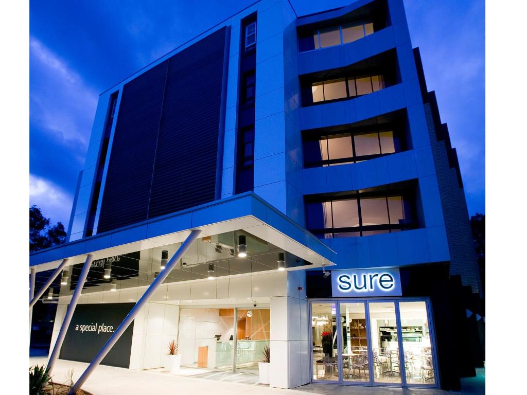 a blue building with a snire sign in front of it at Hotel Urban St Leonards in Sydney
