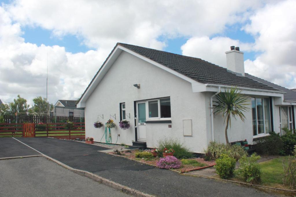 Uma casa branca com uma entrada à frente. em An Airigh em Stornoway