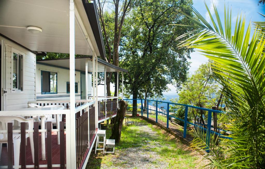 une terrasse couverte d'une maison avec une clôture et des arbres dans l'établissement Camping Genova Est, à Bogliasco