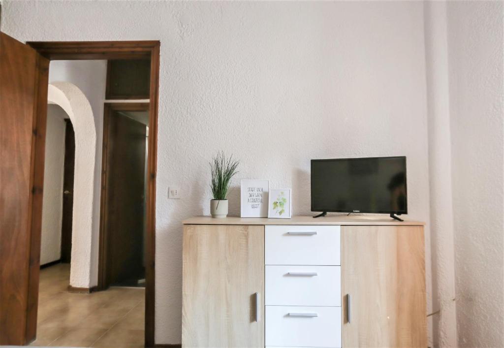 una TV seduta sopra un comò in legno di Beachfront deluxe apt. a Pefkohori