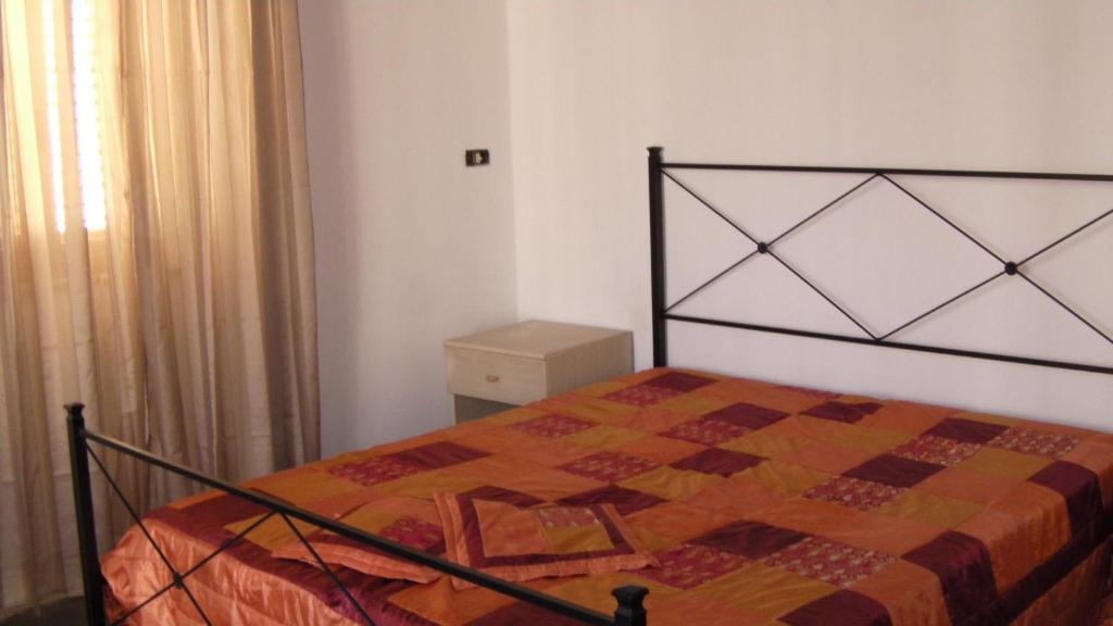 a bedroom with a bed with a quilt on it at Appartamento Gioiosa Marea in Gioiosa Marea