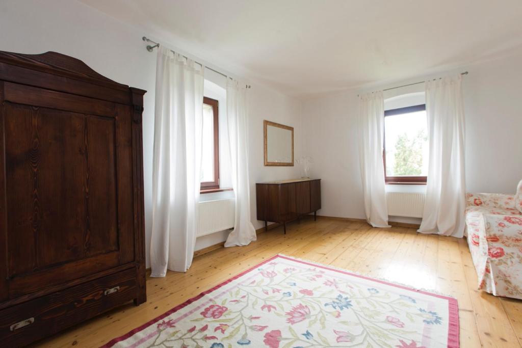 Dom Tomkowice في Tomkowice: غرفة معيشة مع سرير وخزانة ملابس ونوافذ