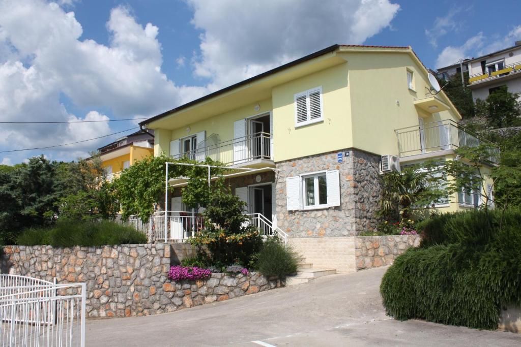 a yellow house with a stone wall at Apartments Lidija in Sveti Juraj