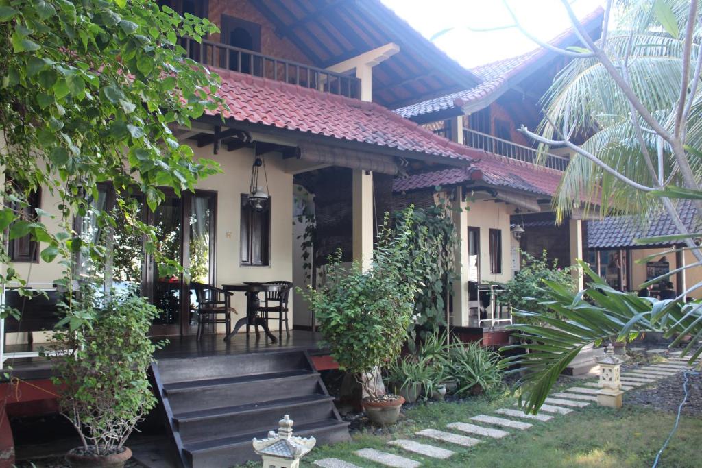 a house with a porch with a table and chairs at Bali Villa coral in Amed