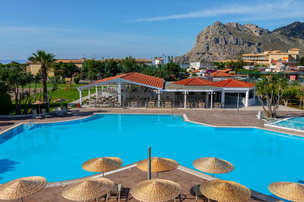 uma grande piscina com cadeiras e guarda-sóis em Leonardo Kolymbia Resort Rhodes em Kolimbia