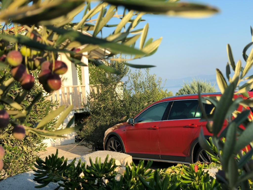 a red car parked in front of a house at Villa Maslina in Sutivan