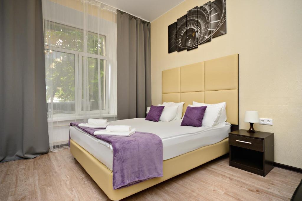 um quarto com uma cama grande com lençóis roxos e uma janela em Hotel Orange Leninsky Avenue em Moscou