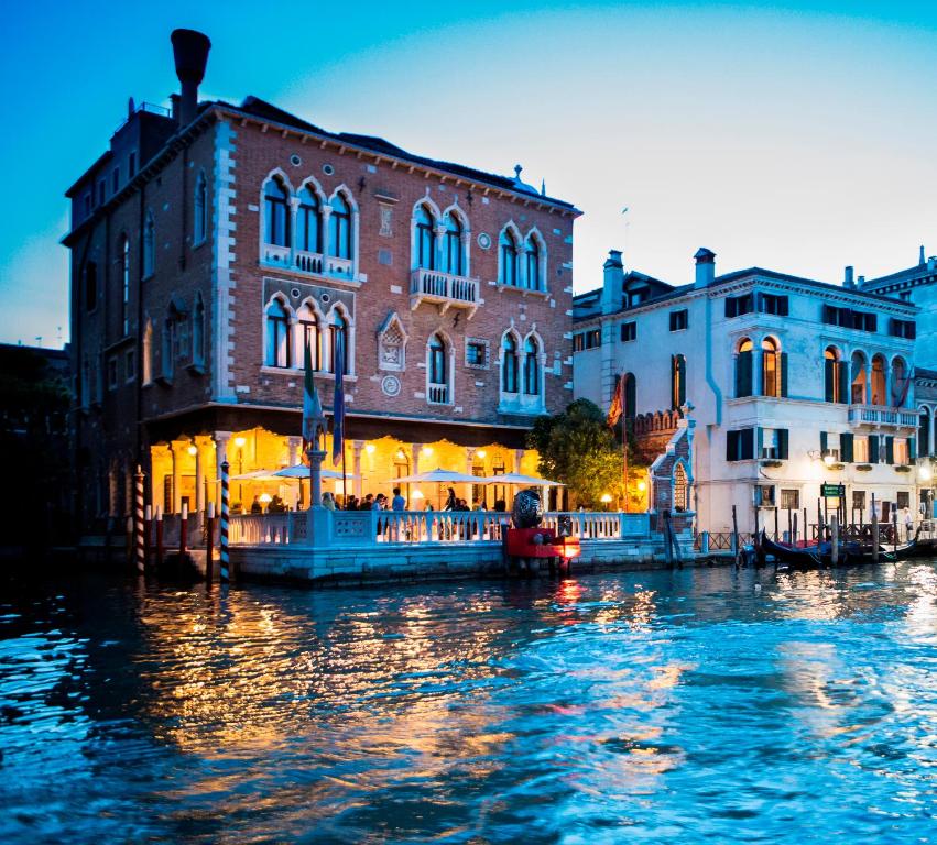 
a river with a large building and a boat in it at Hotel Palazzo Stern in Venice
