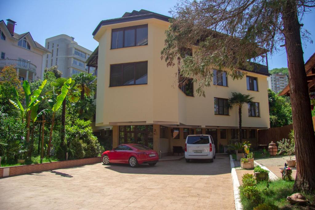 a building with two cars parked in a parking lot at Guest House Matsesta in Matsesta
