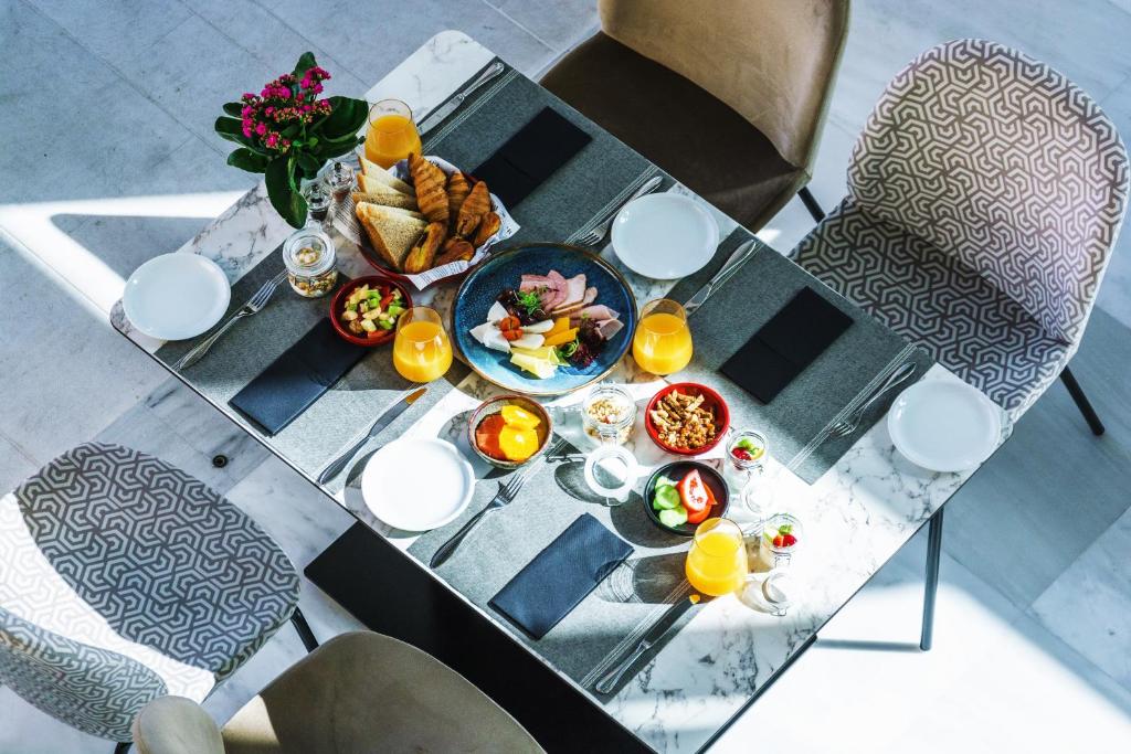 a table with a plate of food and orange juice at Elysia Park in Paphos
