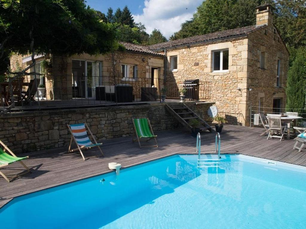 uma piscina em frente a uma casa em le breuil em Sarlat-la-Canéda