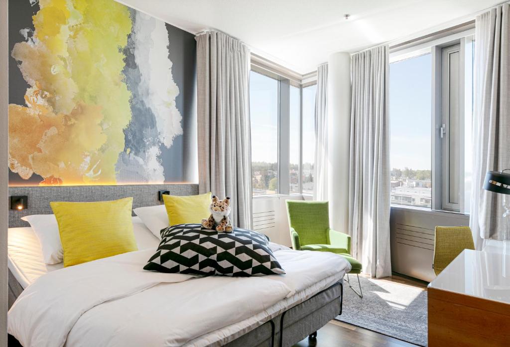1 dormitorio con 1 cama con una pintura en la pared en GLO Hotel Sello en Espoo